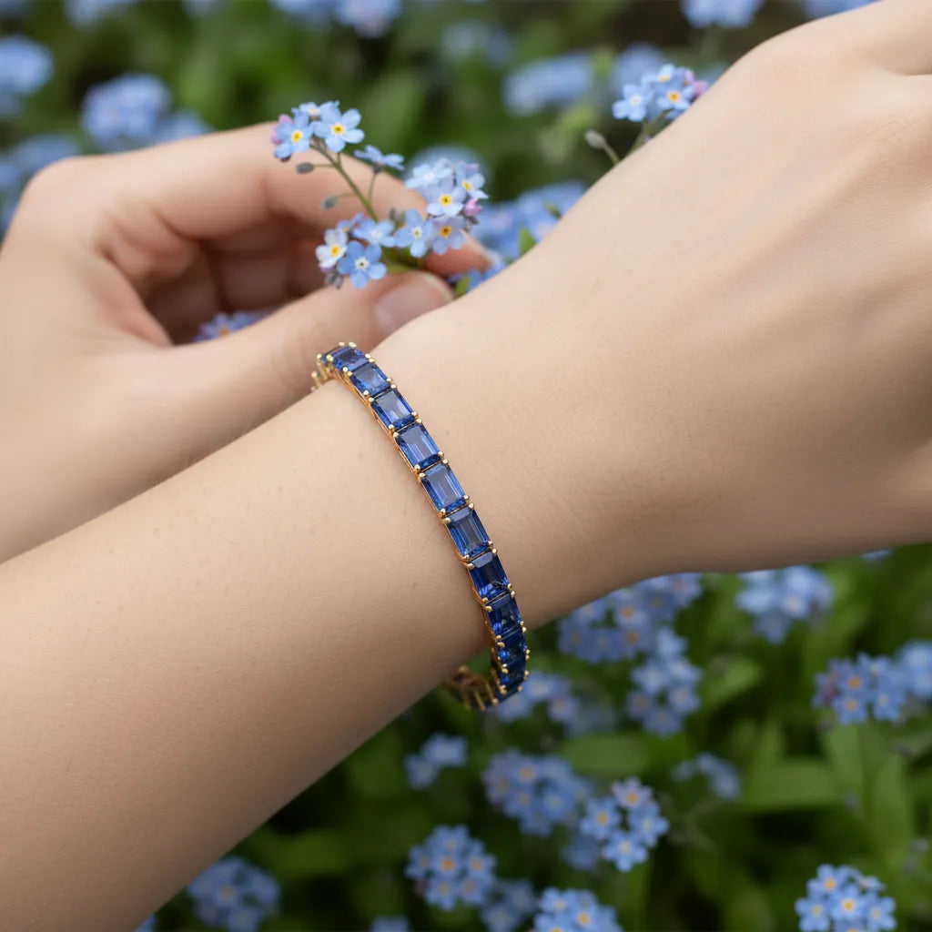 Tennisarmband mit smaragdgeschliffenem (6x4mm) kornblumenblauem Laborsaphir in 18 Karat Gelbgold-Vermeil